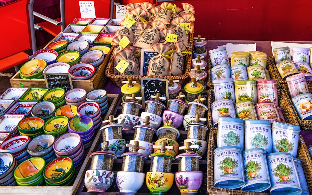Provence market stall with colorful bowls, spice jars, and lavender-themed products.