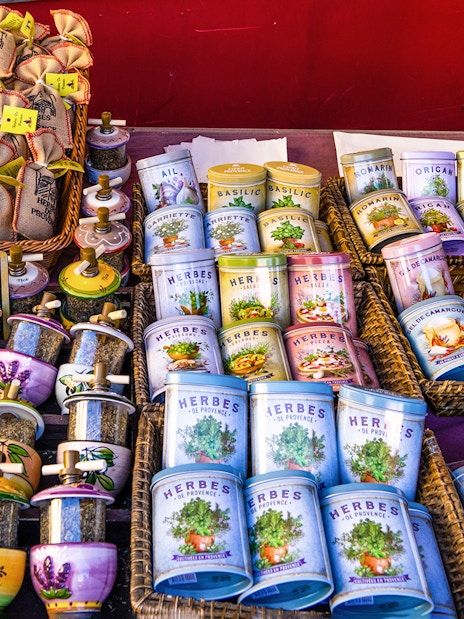 Provence market stall with colorful bowls, spice jars, and lavender-themed products.