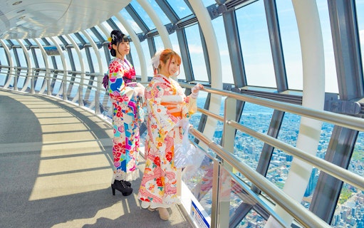 Visitors in kimonos enjoying the view from Tokyo Skytree observation deck.