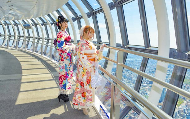 Visitors in kimonos enjoying the view from Tokyo Skytree observation deck.