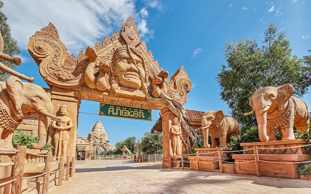 Entrance to Angkor-themed area at PortAventura with elephant statues and intricate carvings.