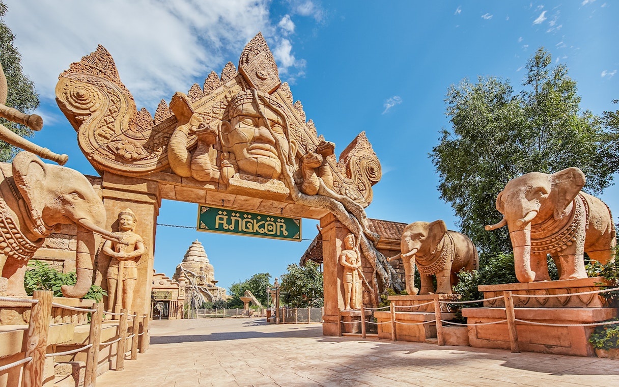 Entrance to Angkor-themed area at PortAventura with elephant statues and intricate carvings.