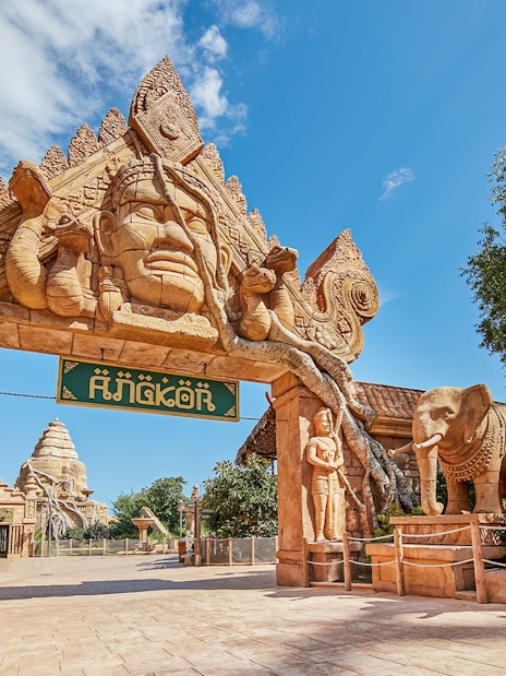 Entrance to Angkor-themed area at PortAventura with elephant statues and intricate carvings.