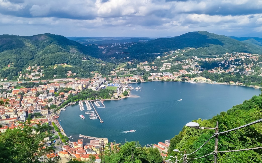 Panoramic view of Lake Como from Brunate with surrounding hills and town.