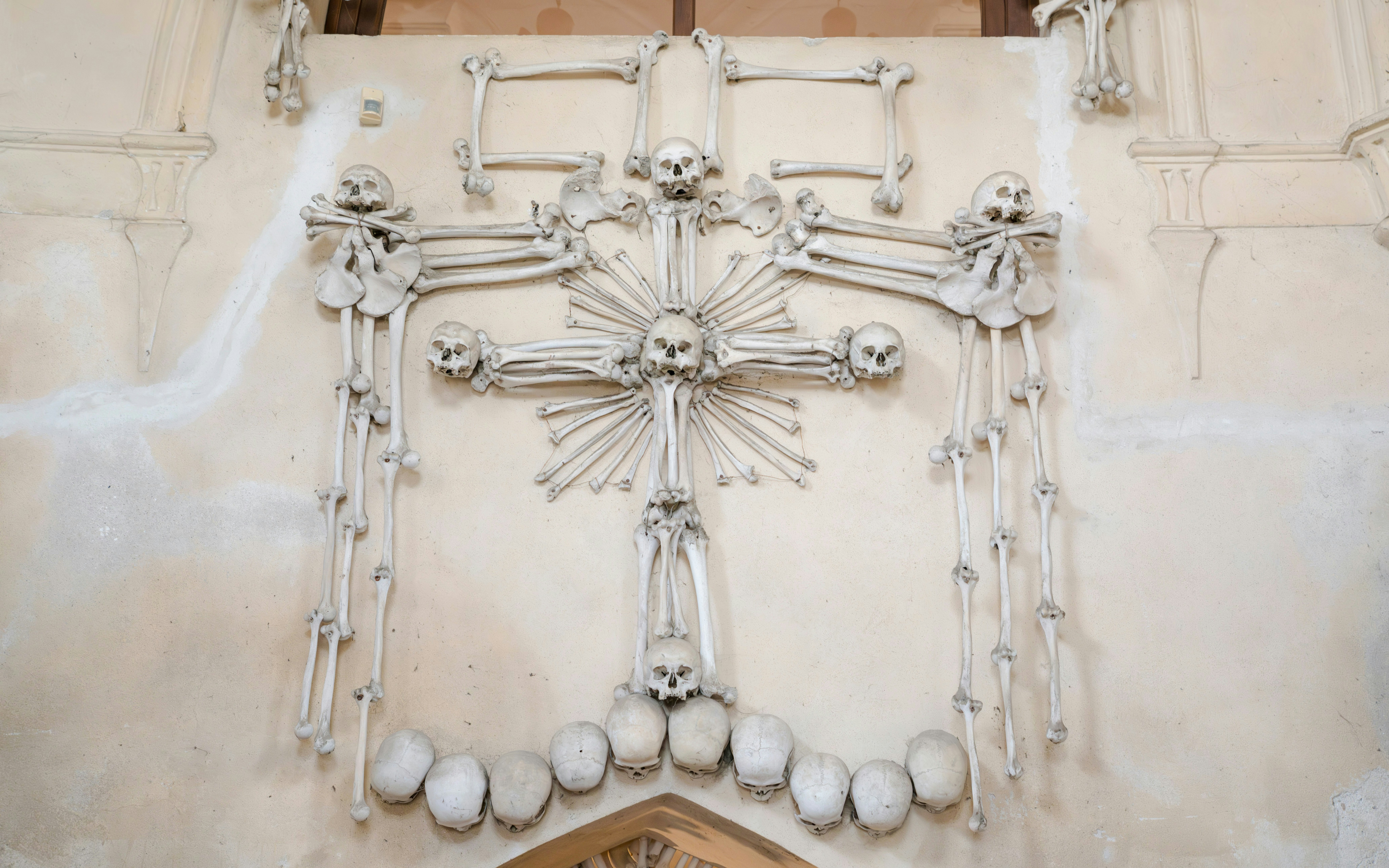 Cross made of human skulls and bones at Sedlec Ossuary, Czech Republic.