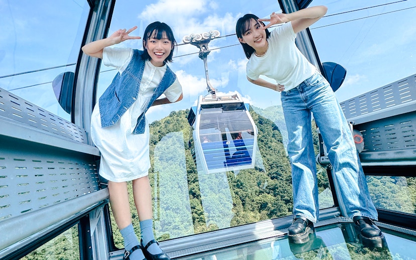 Tourists posing inside cable car on Lantau Island with scenic view.