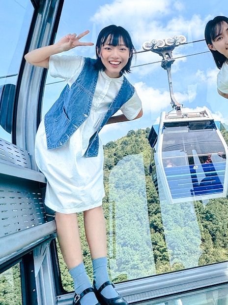 Tourists posing inside cable car on Lantau Island with scenic view.