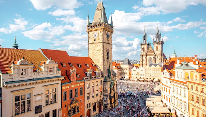 Cityscape view on the clock tower and Tyn cathedral on the old square in Prague.