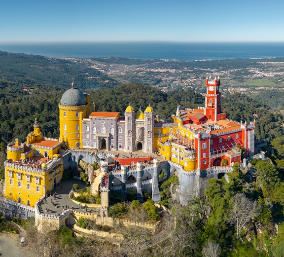 Pena Palace in Sintra, Portugal, with colorful architecture and surrounding forest.