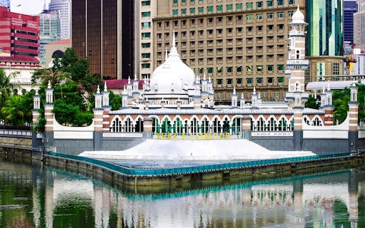 Kuala Lumpur's Jamek Mosque with city skyline in the background.