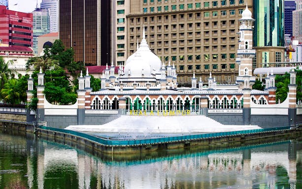 Kuala Lumpur's Jamek Mosque with city skyline in the background.