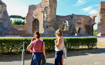 Visitors exploring the ancient Baths of Caracalla ruins in Rome, Italy.