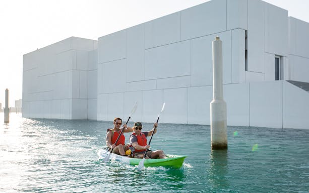 Kayakers paddling near Louvre Abu Dhabi on a guided tour.