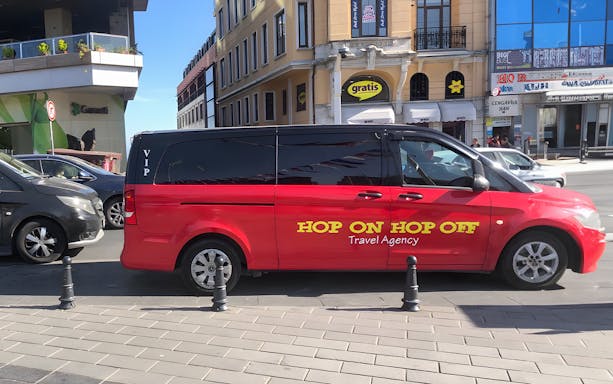 Red VIP Hop On Hop Off tour van parked in Istanbul street.