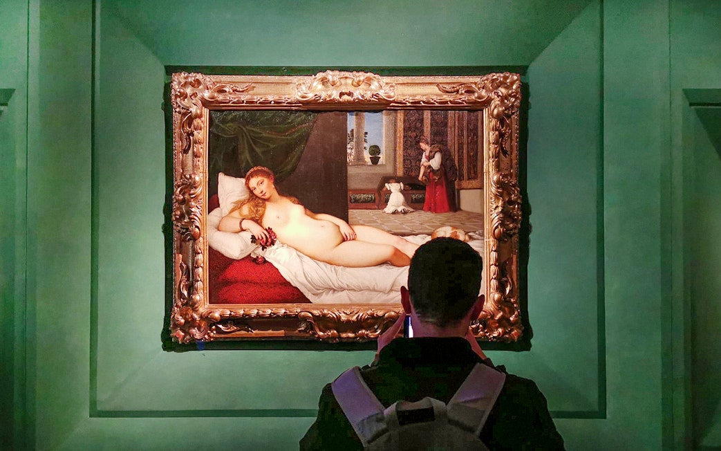 Visitor viewing 'The Venus of Urbino' by Titian at Uffizi Gallery, Florence.