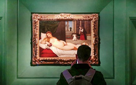 Visitor viewing 'The Venus of Urbino' by Titian at Uffizi Gallery, Florence.