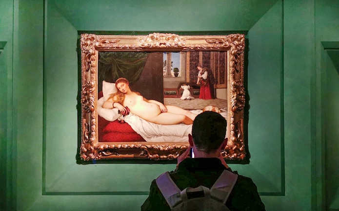 Visitor viewing 'The Venus of Urbino' by Titian at Uffizi Gallery, Florence.