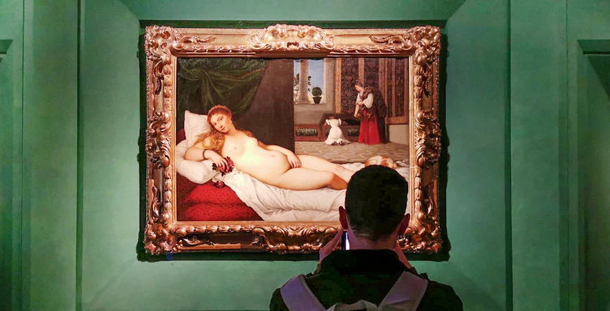 Visitor viewing 'The Venus of Urbino' by Titian at Uffizi Gallery, Florence.