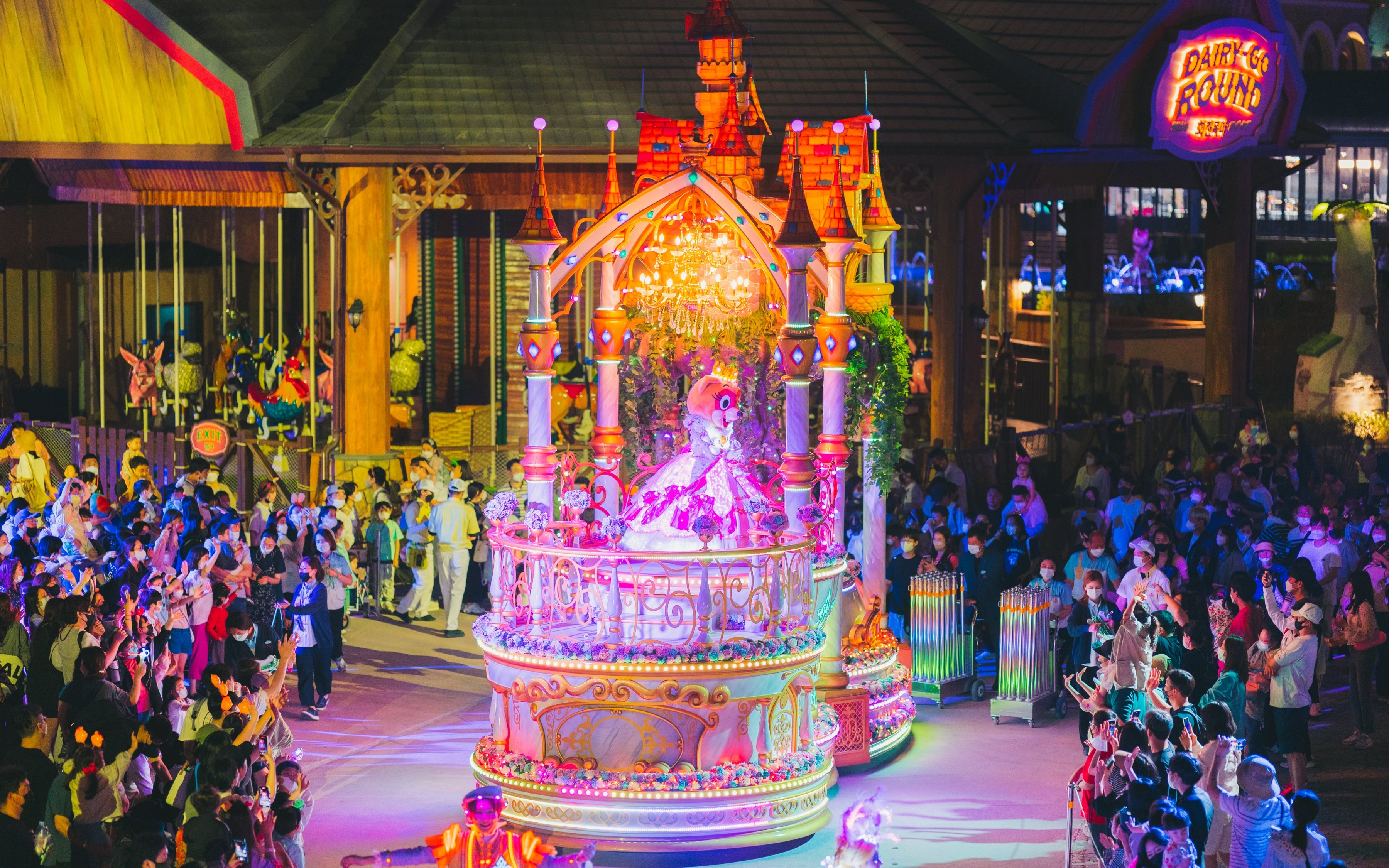 Performance parade at Lotte World Adventure Busan with colorful float and crowd.