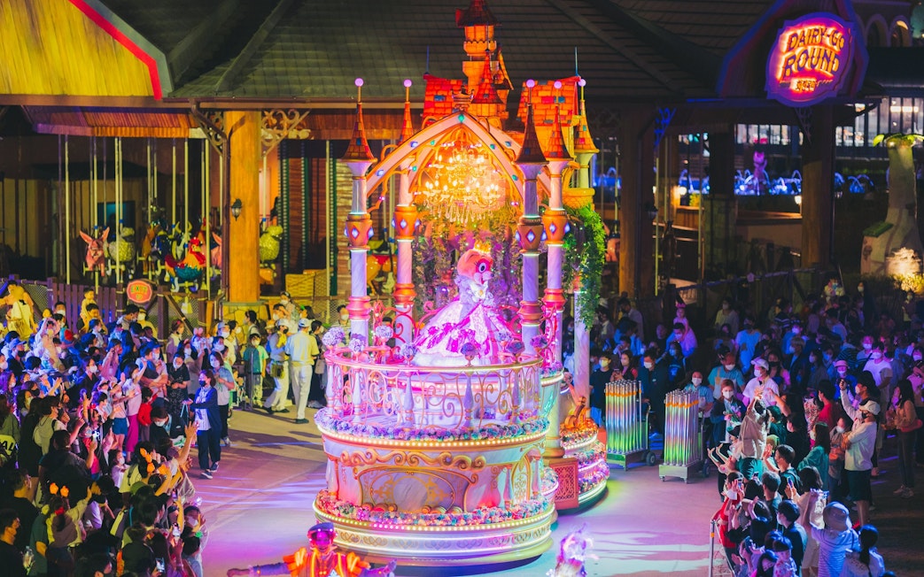 Performance parade at Lotte World Adventure Busan with colorful float and crowd.