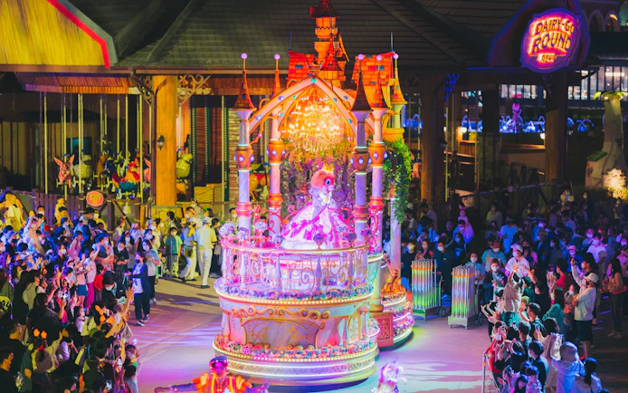 Performance parade at Lotte World Adventure Busan with colorful float and crowd.