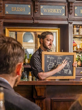Guide explaining whiskey distillation at Irish Whiskey Museum in Dublin, Ireland.