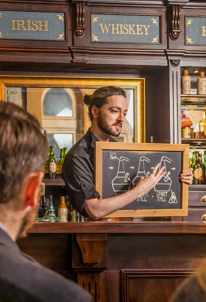 Guide explaining whiskey distillation at Irish Whiskey Museum in Dublin, Ireland.