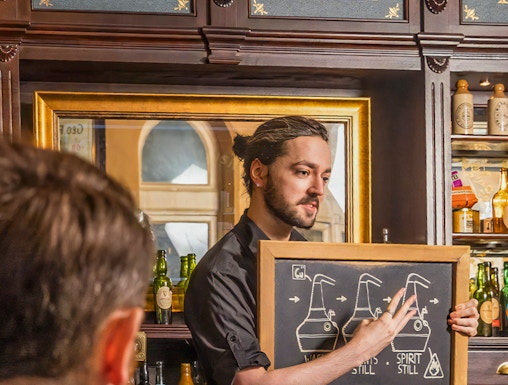 Guide explaining whiskey distillation at Irish Whiskey Museum in Dublin, Ireland.
