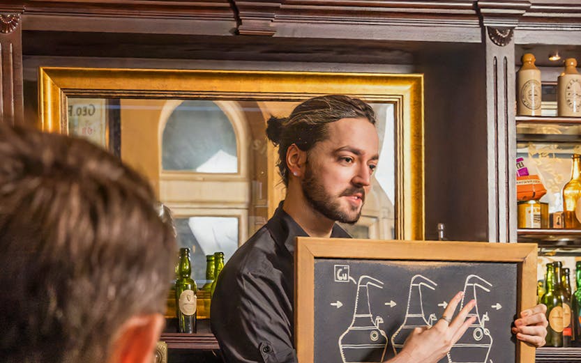 Guide explaining whiskey distillation at Irish Whiskey Museum in Dublin, Ireland.