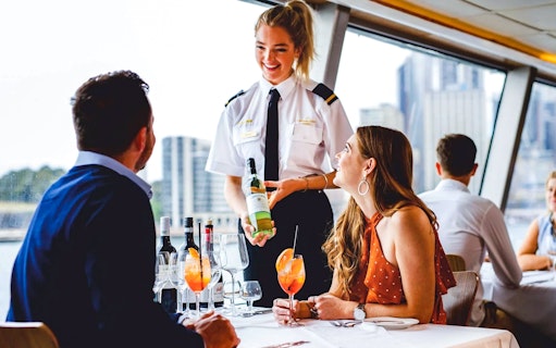 Server presenting wine to a couple on a Sydney Harbour lunch cruise.