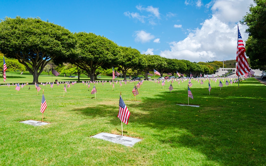 Graves with American flags at Punchbowl National Memorial Cemetery of the Pacific.