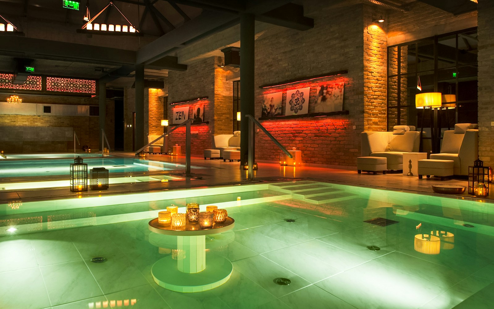Mandala Day Spa interior with illuminated pool and cozy seating area.