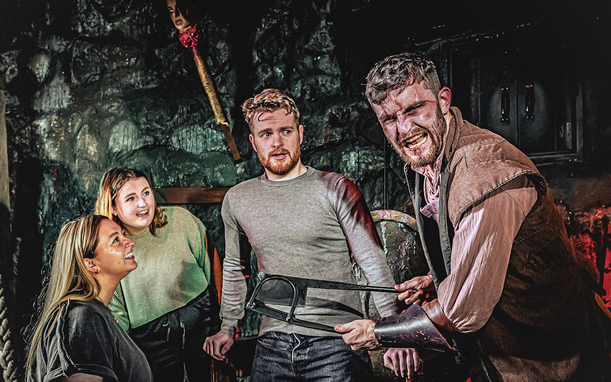 Guests interacting with actor in London Dungeon Torture Chamber.