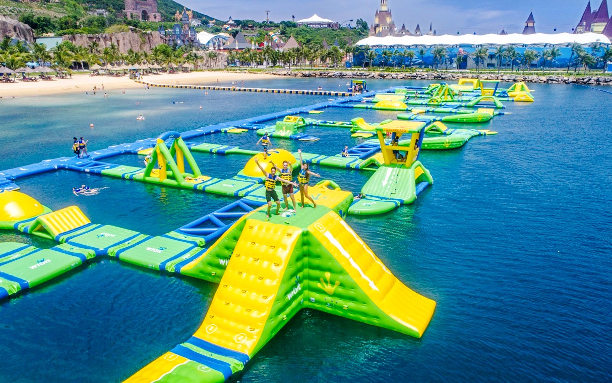 Inflatable obstacle course on water at VinWonders, Nha Trang with people enjoying activities.