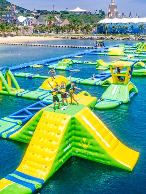 Inflatable obstacle course on water at VinWonders, Nha Trang with people enjoying activities.