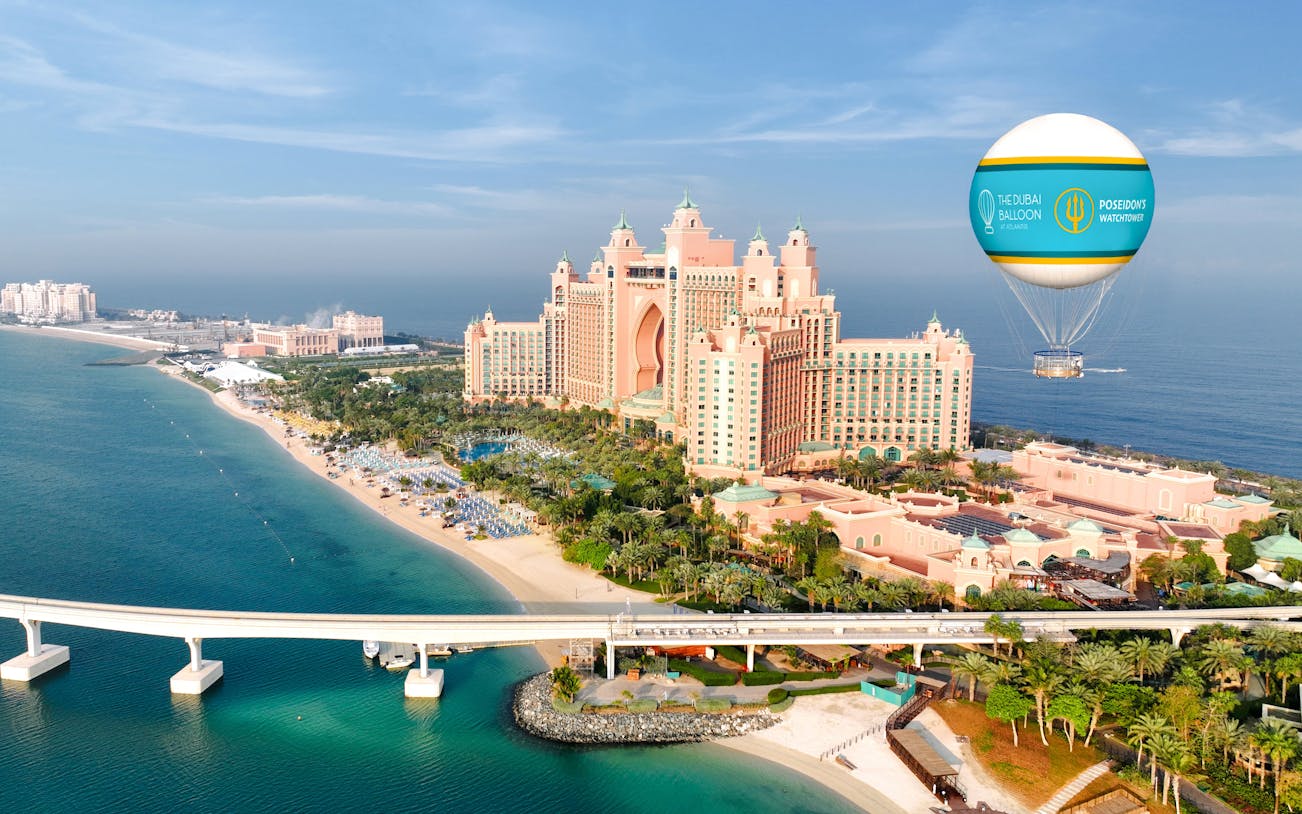 Hot air balloon over Atlantis The Palm, Dubai, with beach and resort view.