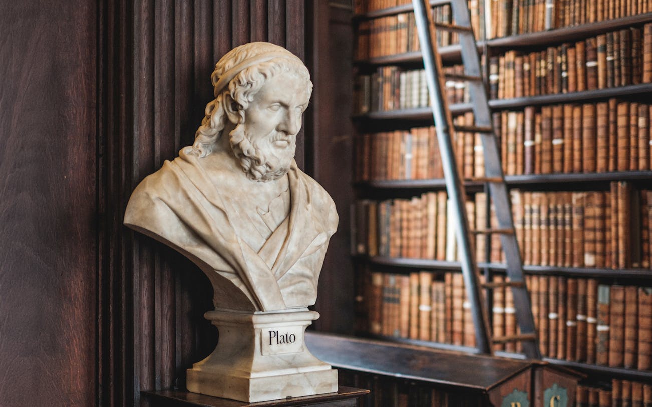 Bust of Plato in the Library of Trinity College, Dublin, with shelves of books in the background.