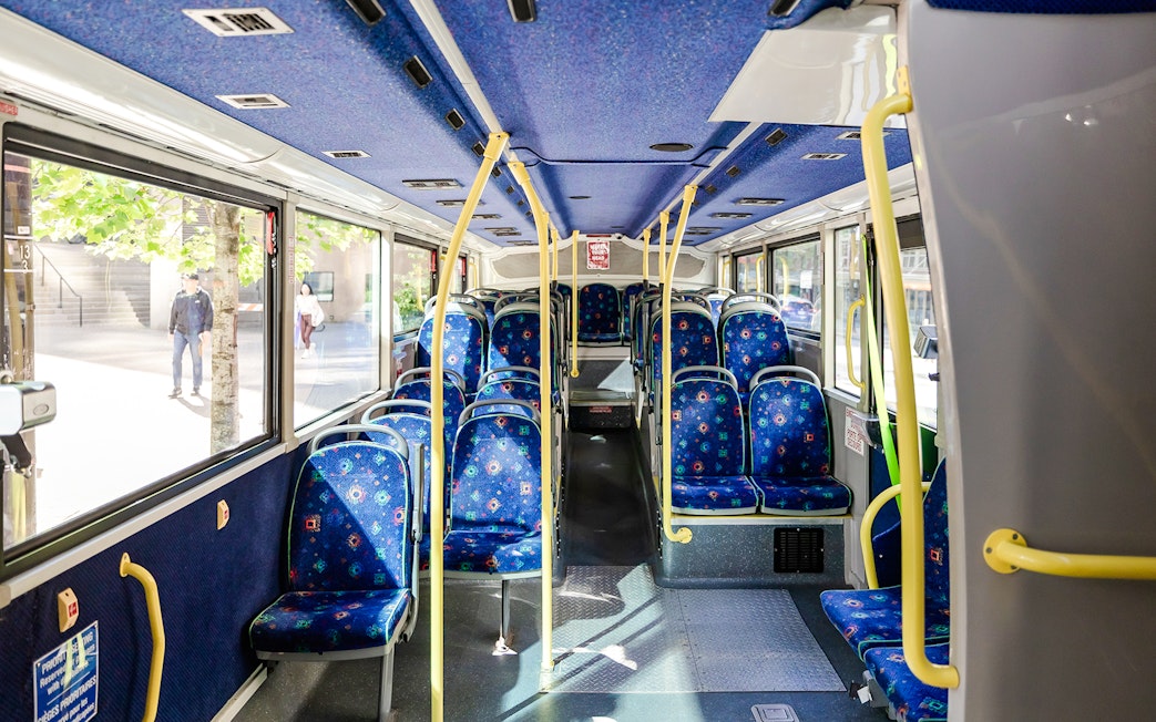 Interior of a Big Bus Vancouver tour bus with empty blue patterned seats.