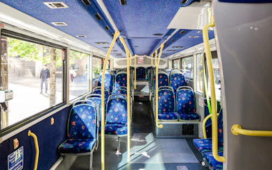 Interior of a Big Bus Vancouver tour bus with empty blue patterned seats.