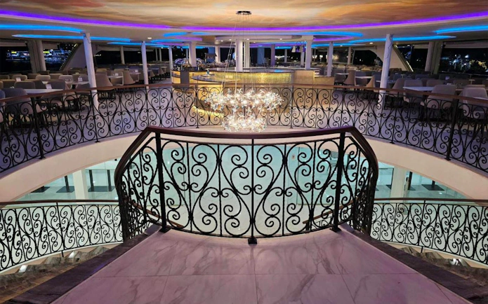 Elegant dining area on Noah Cruise ship in Bangkok with ornate railings and chandelier.