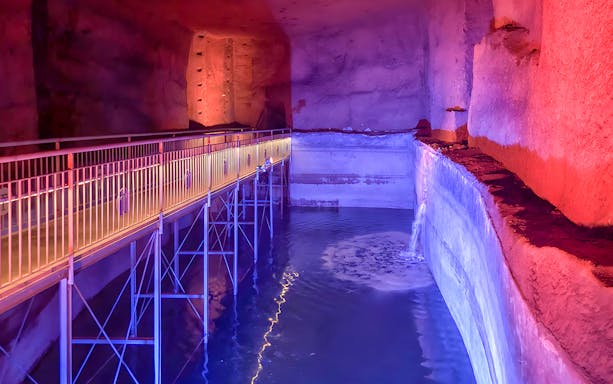 Underground walkway with colorful lighting at LAPIS Museum, Naples.