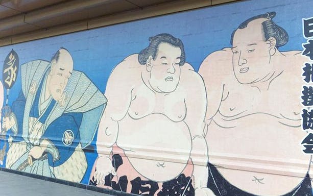 Graffiti mural depicting sumo wrestlers in traditional attire.