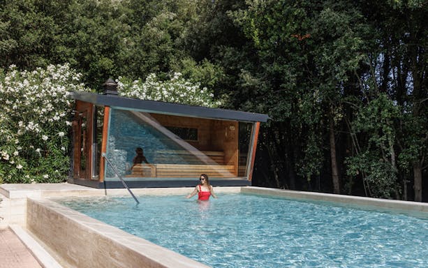 Visitor swimming at QC Terme Roma Resort & Spa pool, Italy.