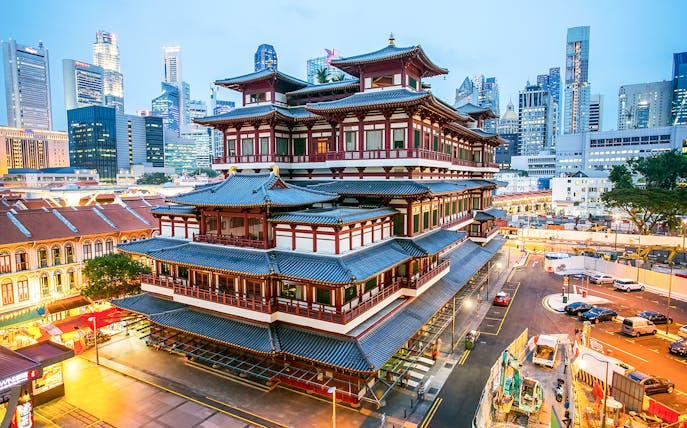 Buddha Tooth Relic Temple in Chinatown, Singapore with city skyline in the background.