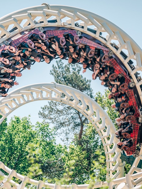 Roller coaster loop at Efteling theme park, Netherlands, with riders enjoying the thrill.