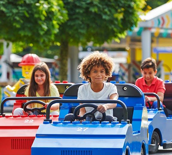 Children driving mini cars at Legoland Windsor Resort, London.