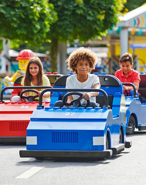 Children driving mini cars at Legoland Windsor Resort, London.