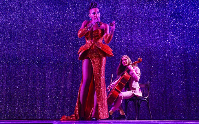 Performer singing with cellist at Paradis Latin festive show.