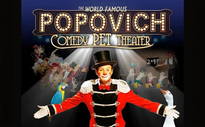 Performer in top hat with animals at Popovich Comedy Pet Theater.
