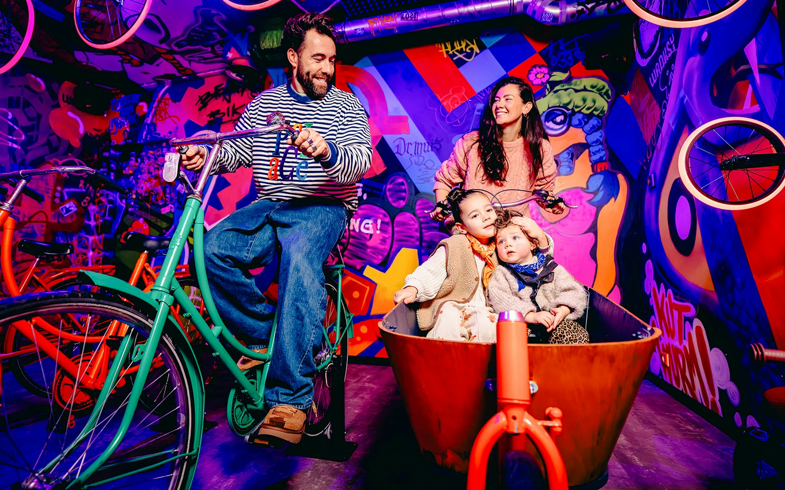 Guests enjoying a colorful bike ride in a vibrant, graffiti-filled space in Holland.